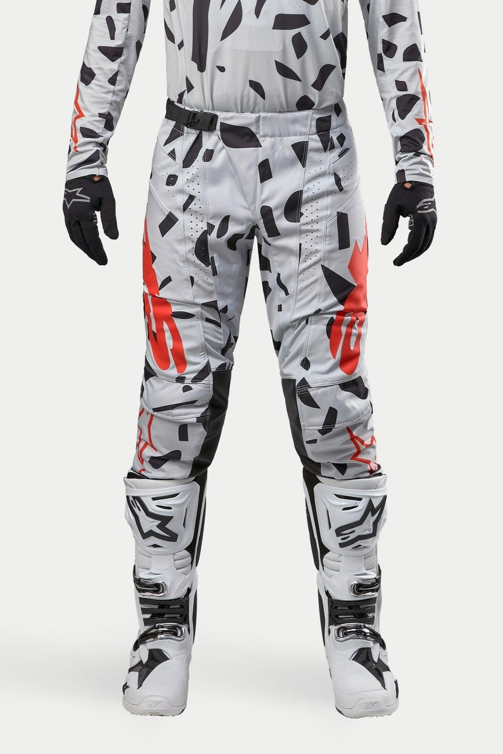 Calças Alpinestars 2024 Techstar Rantera, calças de motocross, cinzento Haze Gray Camo, usadas com jersey a condizer, luvas pretas e botas brancas, com padrão de manchas pretas e logótipo Alpinestars em vermelho, design durável para corridas de todo-o-terreno