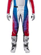 Alpinestars 2024 Techstar Pneuma Pants, calças de motocross, azul, vermelho e branco com design angular e pormenores em roxo, combinadas com botas brancas e pretas e luvas a condizer, corte atlético de competição para performance em todo-o-terreno