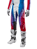 Alpinestars 2024 Techstar Pneuma Pants, calças de motocross, Blu Mars Red White, usadas com camisola a condizer, botas de corrida e luvas brancas, design gráfico vibrante com realces em vermelho, azul e roxo, perfuradas para respirabilidade