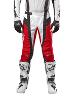 Alpinestars 2024 Techstar Ocuri Pants, calças de motocross, vermelho Mars Red, branco e preto, vista frontal com camisola branca a condizer, luvas pretas e botas brancas, com painéis perfurados respiráveis e um corte inspirado na competição para performance em todo-o-terreno