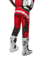 Alpinestars 2024 Techstar Ocuri Pants, calças de motocross, Vermelho Mars, branco e preto, vista traseira com grande logótipo Alpinestars branco no assento, painéis de ventilação em malha preta, usadas com botas de motocross brancas e pretas, design atlético de corte de corrida para condução todo-o-terreno