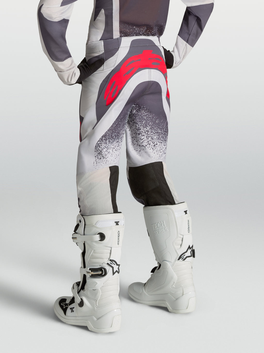 Alpinestars calças Supertech Swan Juventude, calças de motocross cinzentas e lilás com logótipo vermelho, vista traseira.