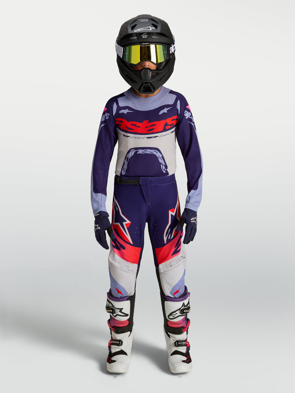 Alpinestars Supertech Dyna Juventude, calças de motocross roxas e rosa fluo, equipamento completo off-road em modelo.