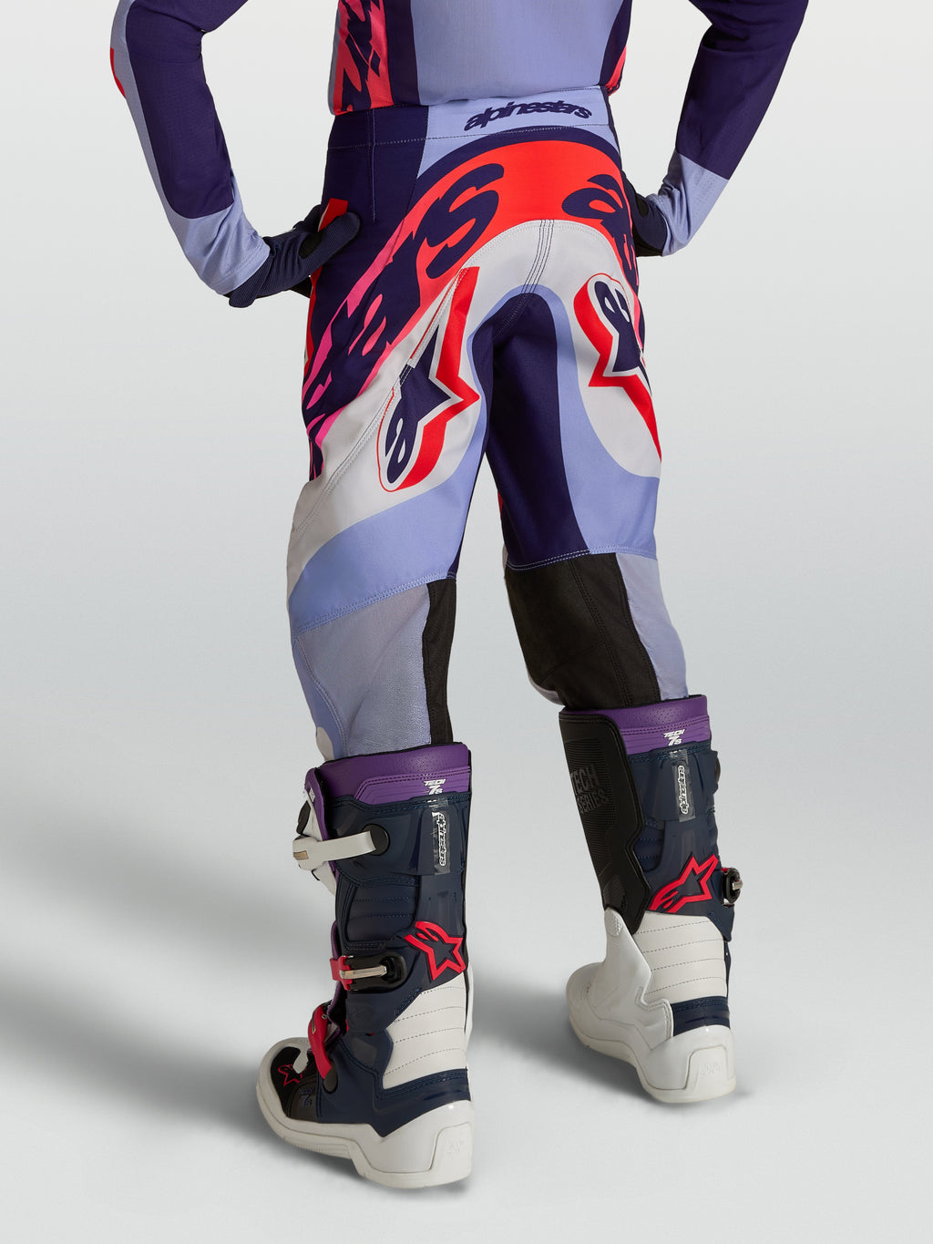 Calças Alpinestars Supertech Dyna Juventude, para motocross, roxas e rosa fluo, em tecido rip-stop elástico, vista traseira.