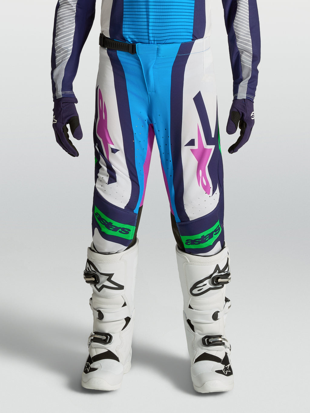 Calças Alpinestars Supertech Maven Juventude, brancas e azuis com detalhes verde fluorescente e ajuste atlético.