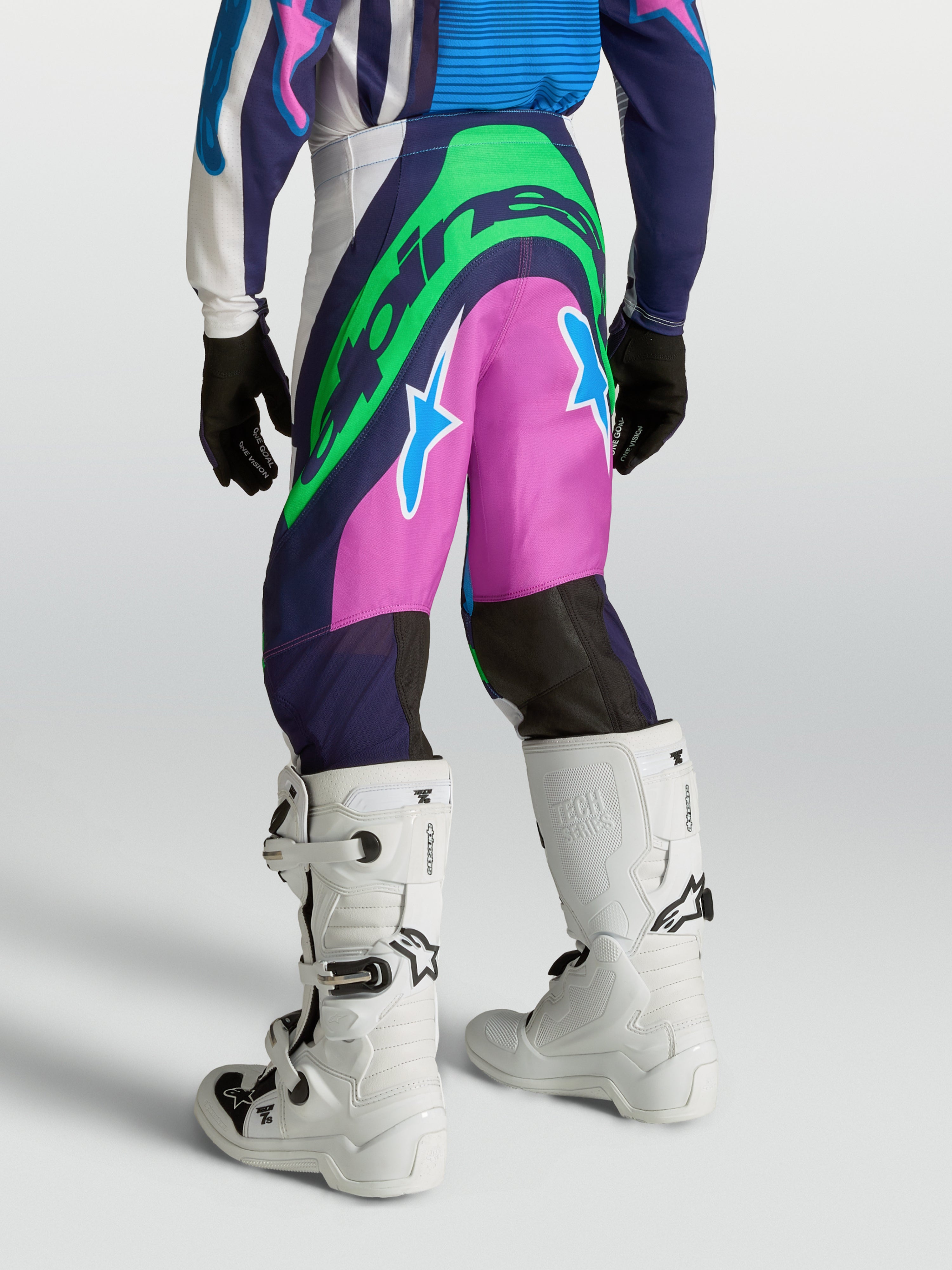 Alpinestars Calças Supertech Maven Juventude, calças de motocross azuis e rosa com verde néon, ajuste atlético no modelo.