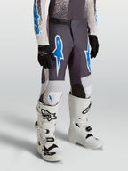 Calças Alpinestars Fluid Drag Juventude para motocross, cinzentas e azuis, em polifabric 600D durável.