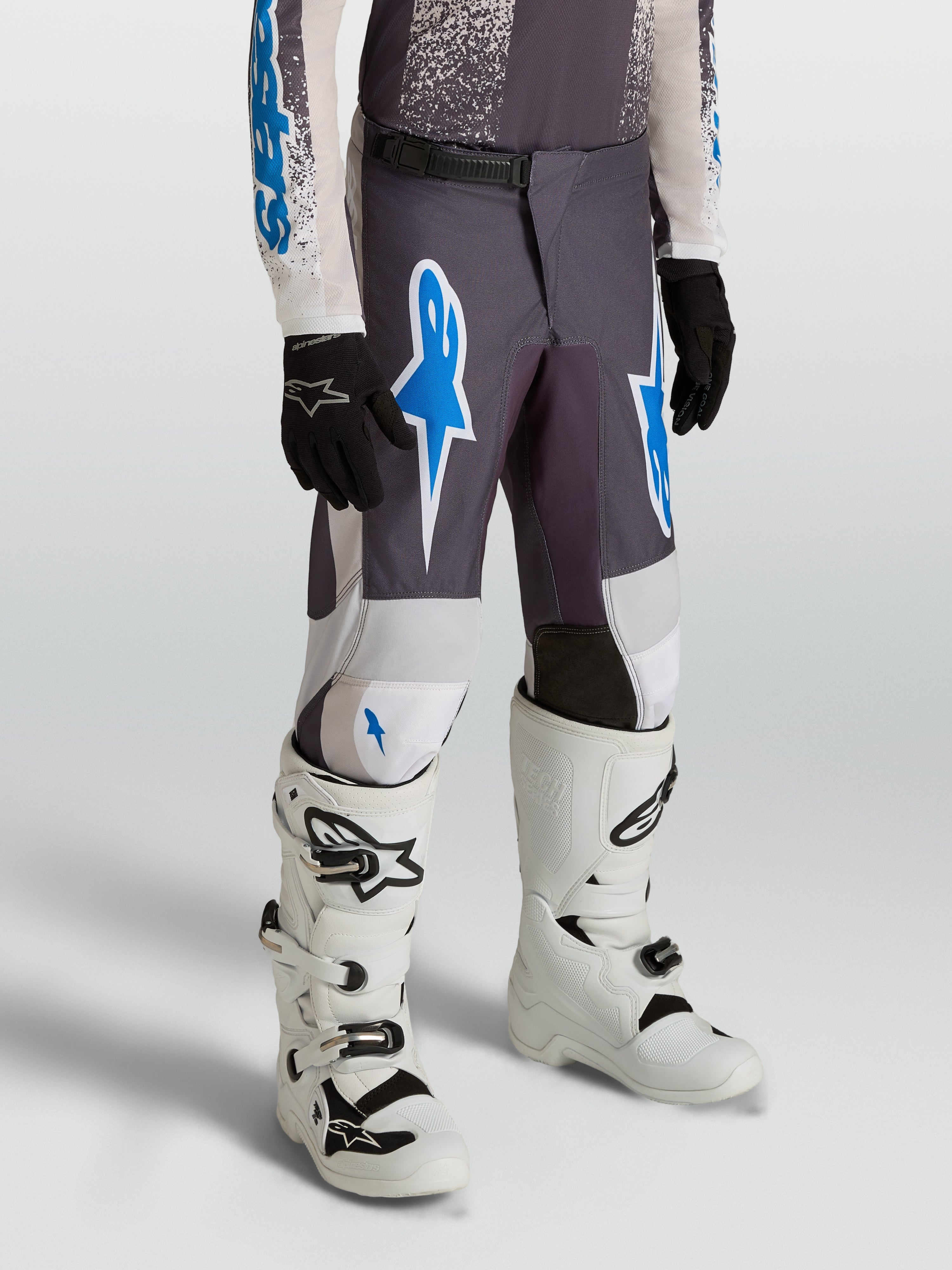 Calças Alpinestars Fluid Drag Juventude para motocross, cinzentas e azuis, em polifabric 600D durável.