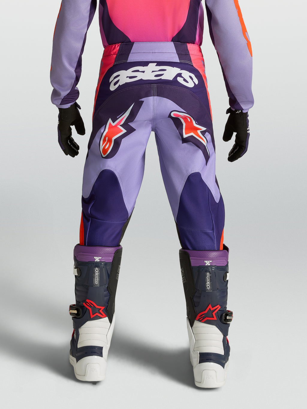 Alpinestars Fluid Hunt Juventude, calças de motocross para jovens, roxas e rosa, vista traseira com logótipos Astars e construção em politecido durável.