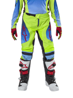 Alpinestars Youth 2024 Racer Hoen Pants, calças de motocross, amarelo néon e azul Night Navy, com logótipos de estrela vermelhos nas coxas, usadas com camisola a condizer, luvas vermelhas e pretas, e botas de motocross brancas, pretas e vermelhas, equipamento resistente para todo-o-terreno