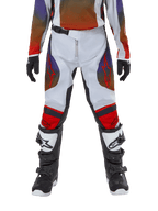 Calças Alpinestars Youth 2024 Racer Hoen, calças de motocross, cinzento claro, laranja vibrante e preto, usadas com camisola a condizer e botas de motocross pretas e brancas, com logótipos Alpinestars vermelhos nas coxas e joelhos, design desportivo para corridas todo-o-terreno