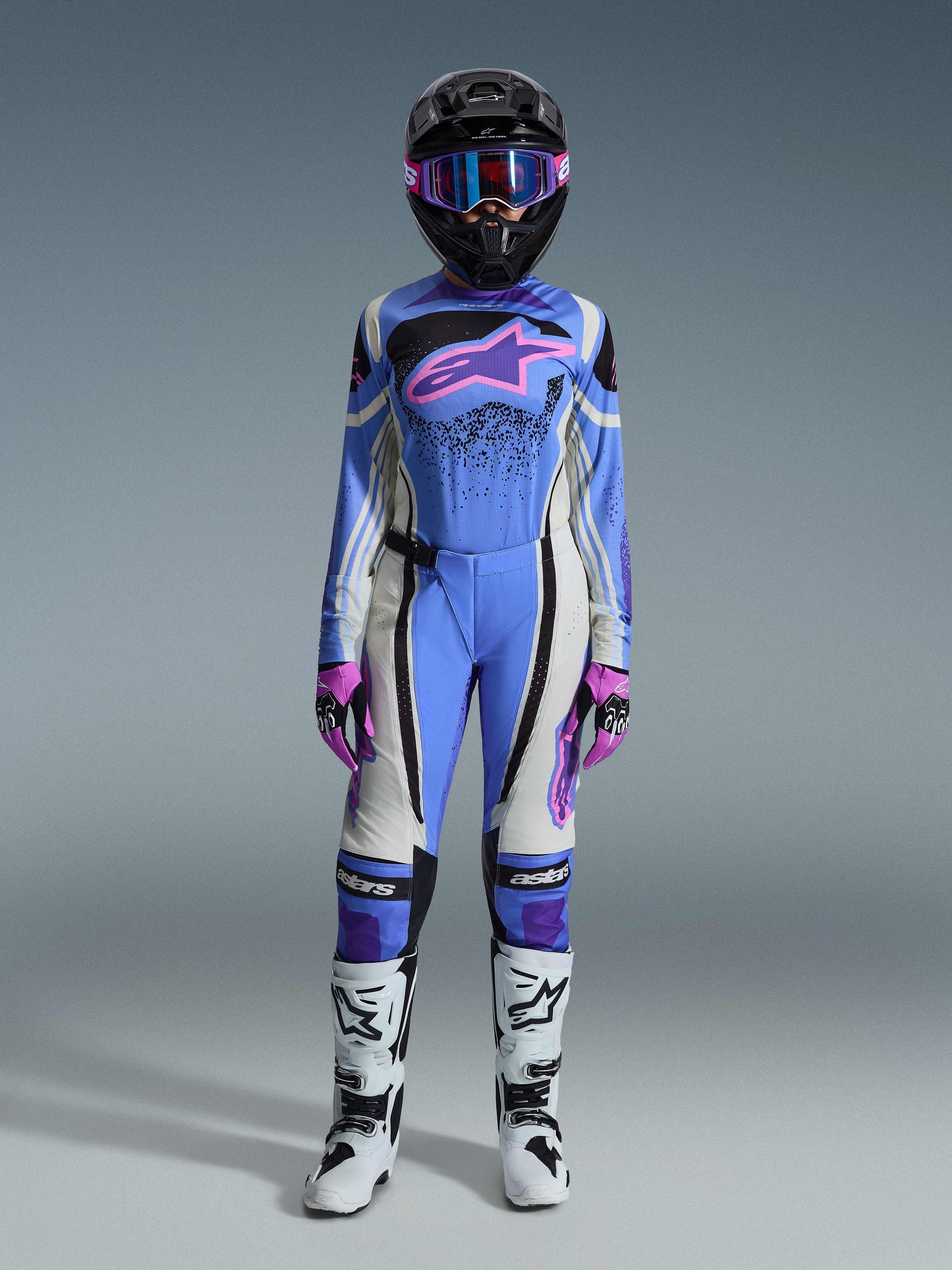 Conjunto de Equipamento Alpinestars Stella Techstar Nomur Feminino 2026, equipamento de corrida de motocross, azul claro, branco e rosa, com capacete preto e óculos rosa, camisola com logótipo de estrela rosa, calças a condizer, luvas rosa e pretas e botas brancas e pretas.
