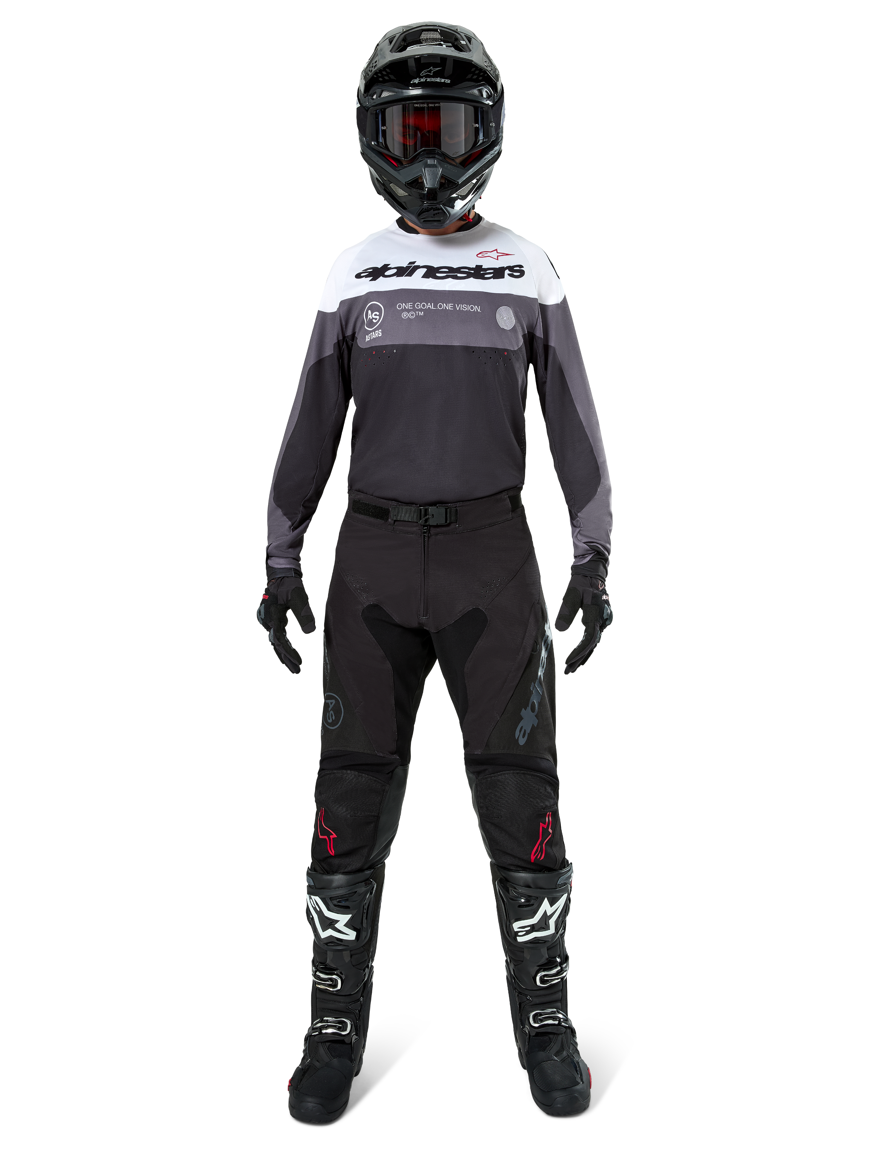 Piloto de motocross com equipamento completo, Camisola Pro-Dura em Black Magnet White com a parte superior do peito branca e detalhes cinzentos, calças pretas, capacete preto com óculos escuros, botas brancas e pretas e luvas pretas, conjunto coordenado para enduro e off-road