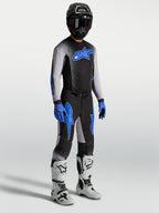Alpinestars Supertech Hiten AFD Gear Set e Camisola, conjunto de motocross para homem, preto e azul com botas brancas.