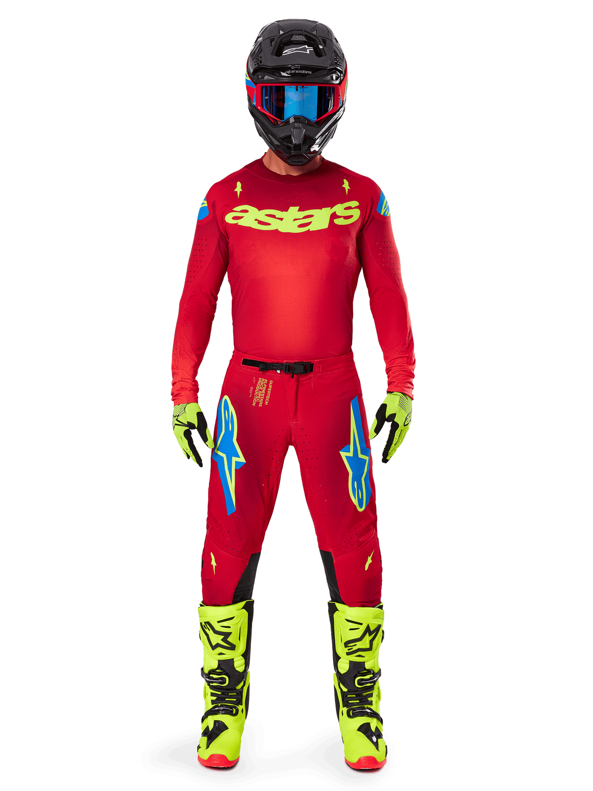 Piloto de motocross a usar o conjunto de equipamento completo Alpinestars 2025 Supertech Maker, camisola em vermelho vivo com a marca 'astars' em amarelo néon, calças vermelhas a condizer com detalhes em azul, capacete preto com óculos azuis, botas e luvas em amarelo néon, conjunto coordenado para corridas fora de estrada