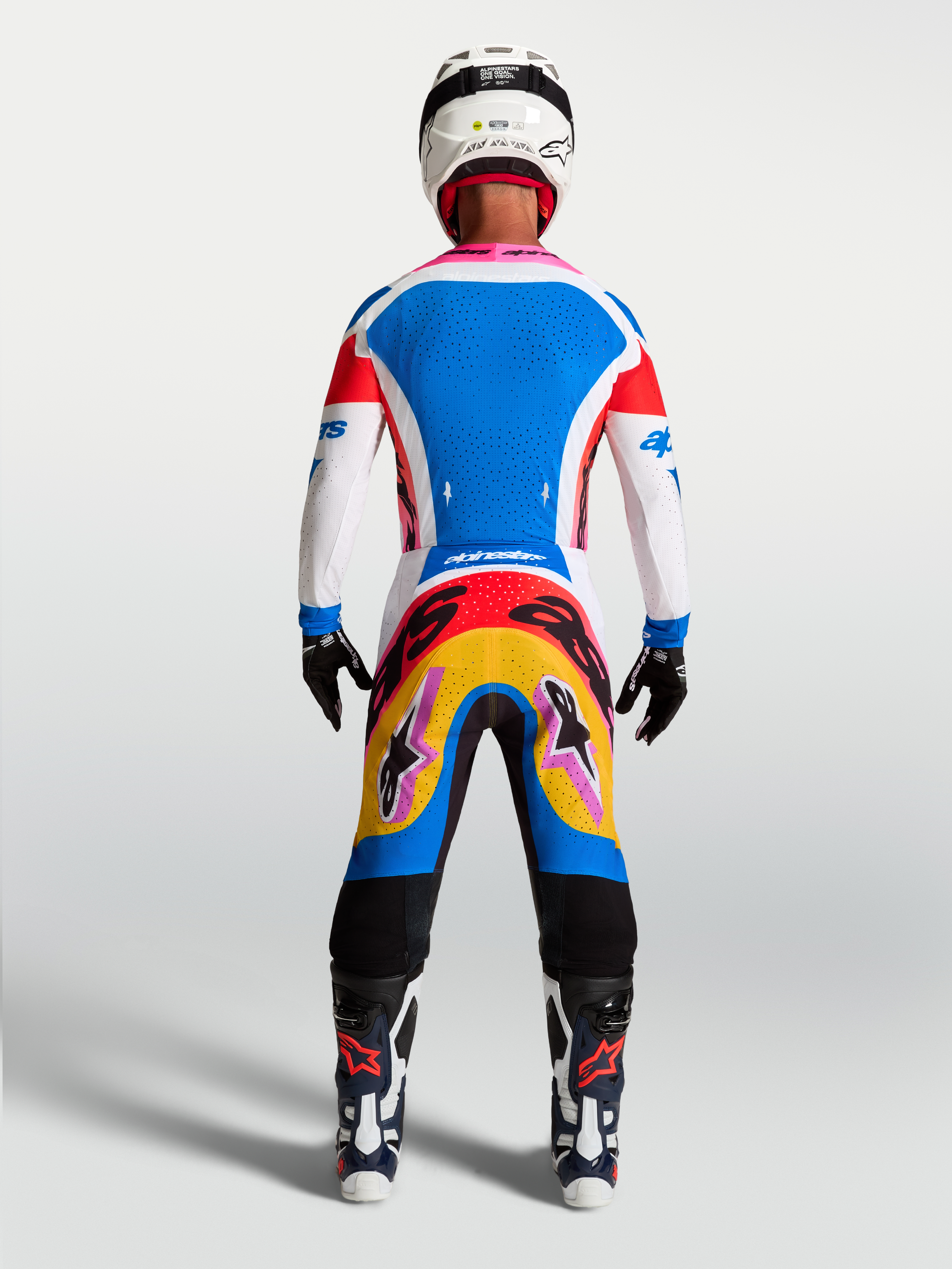 Alpinestars Camisola Supertech Dyna e Conjunto, kit de motocross azul e branco com pormenores rosa, vista traseira no modelo.