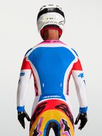 Alpinestars Supertech Dyna, camisola de motocross azul e branca, malha elástica perfurada para ventilação, vista traseira.
