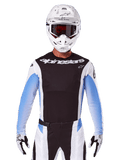 Alpinestars 2025 Techstar Melt Jersey, equipamento de motocross, preto, branco e azul, camisola de manga comprida com calças e luvas coordenadas, piloto com equipamento completo de MX, capacete branco e óculos de proteção