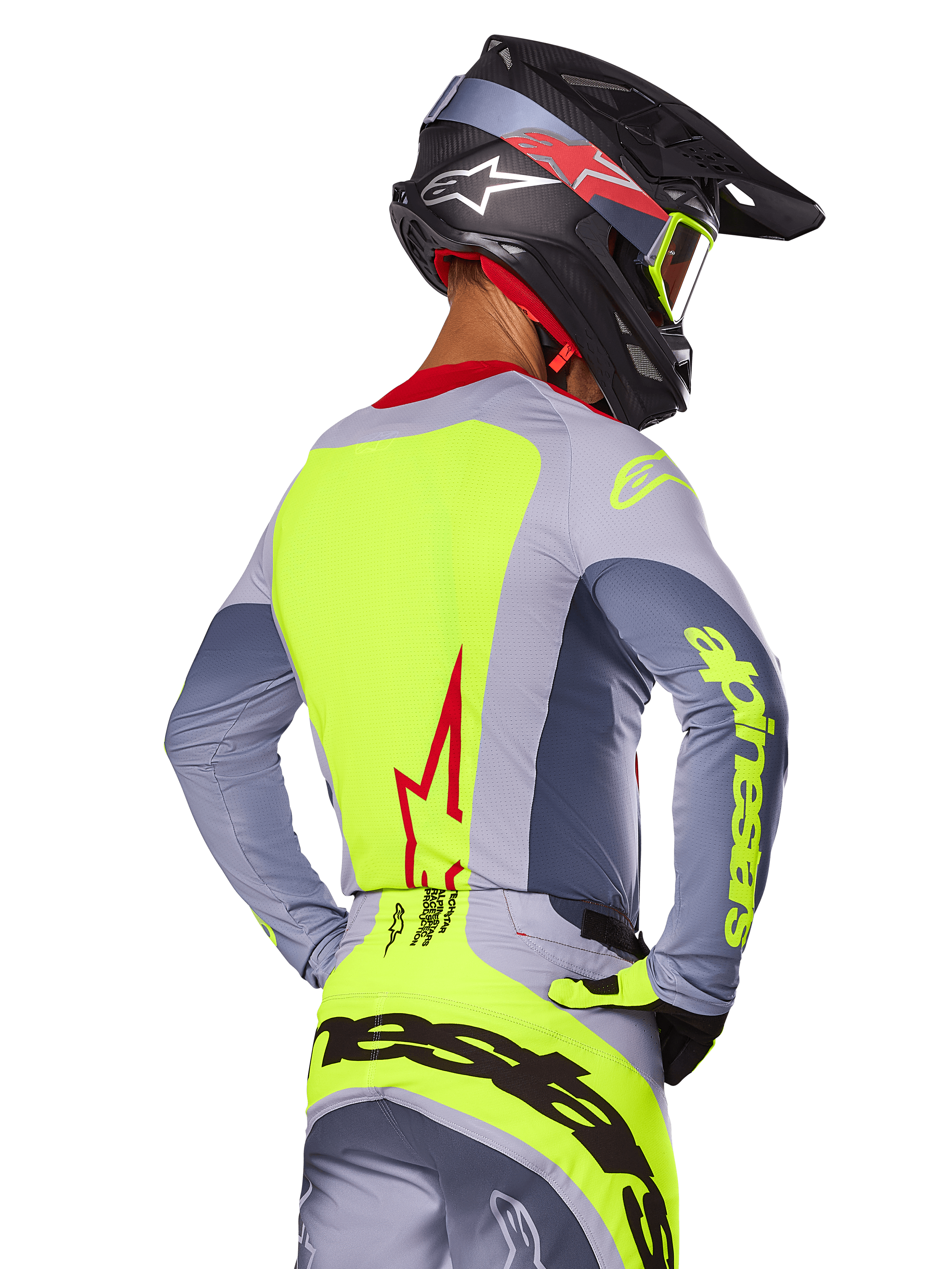 Alpinestars 2025 Techstar Melt Jersey, Bright Red Gray, back view of motocross rider wearing gray and neon yellow racing gear, red star logo on back, matching black and red helmet, performance off-road apparel