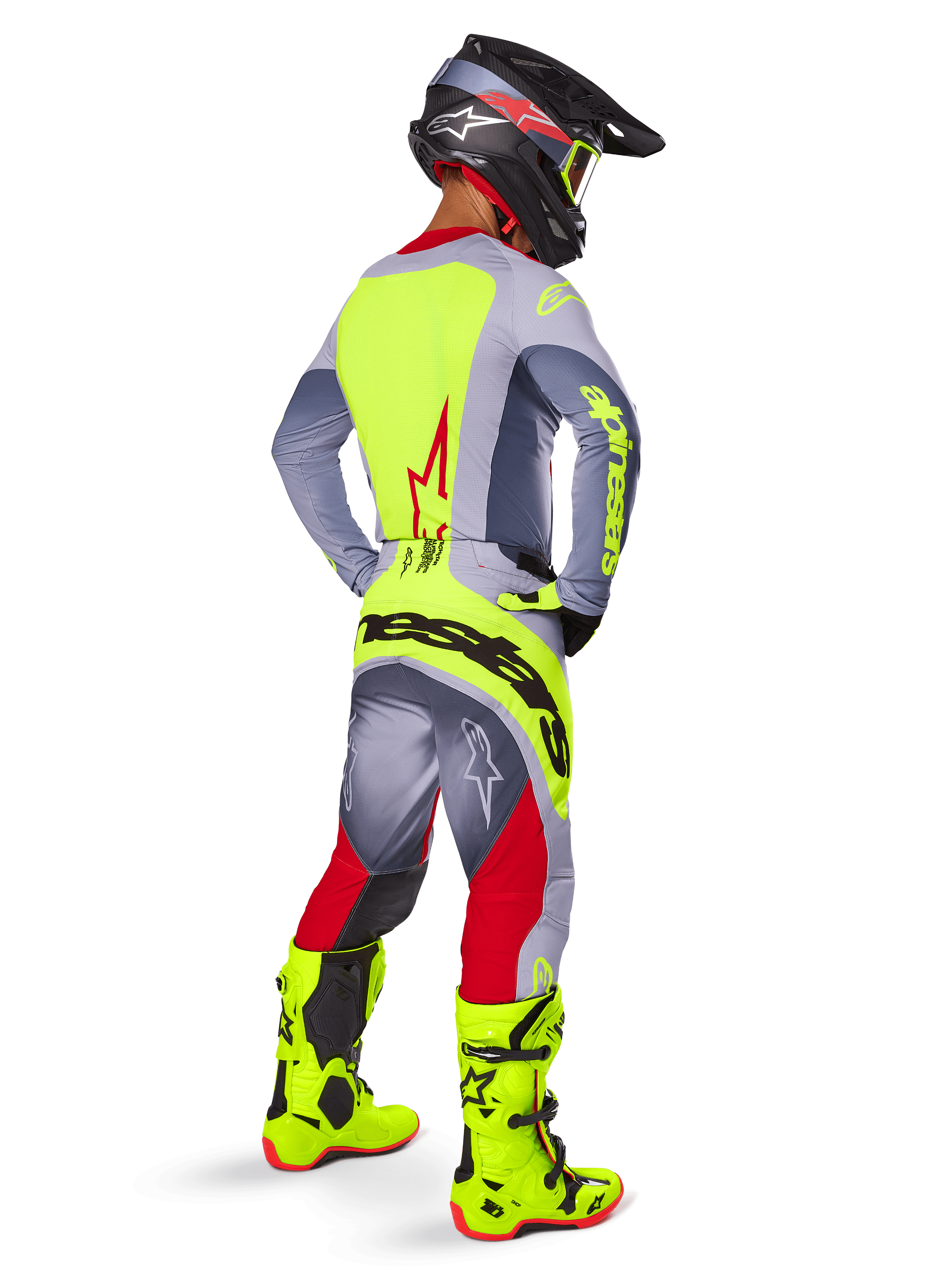 Motocross rider from behind wearing the Alpinestars 2025 Techstar Melt Jersey in Bright Red Gray, featuring a bright yellow back panel and gray sleeves, matching gray and red pants with yellow branding, bright yellow motocross boots, and a black helmet with yellow goggles, coordinated off-road racing kit