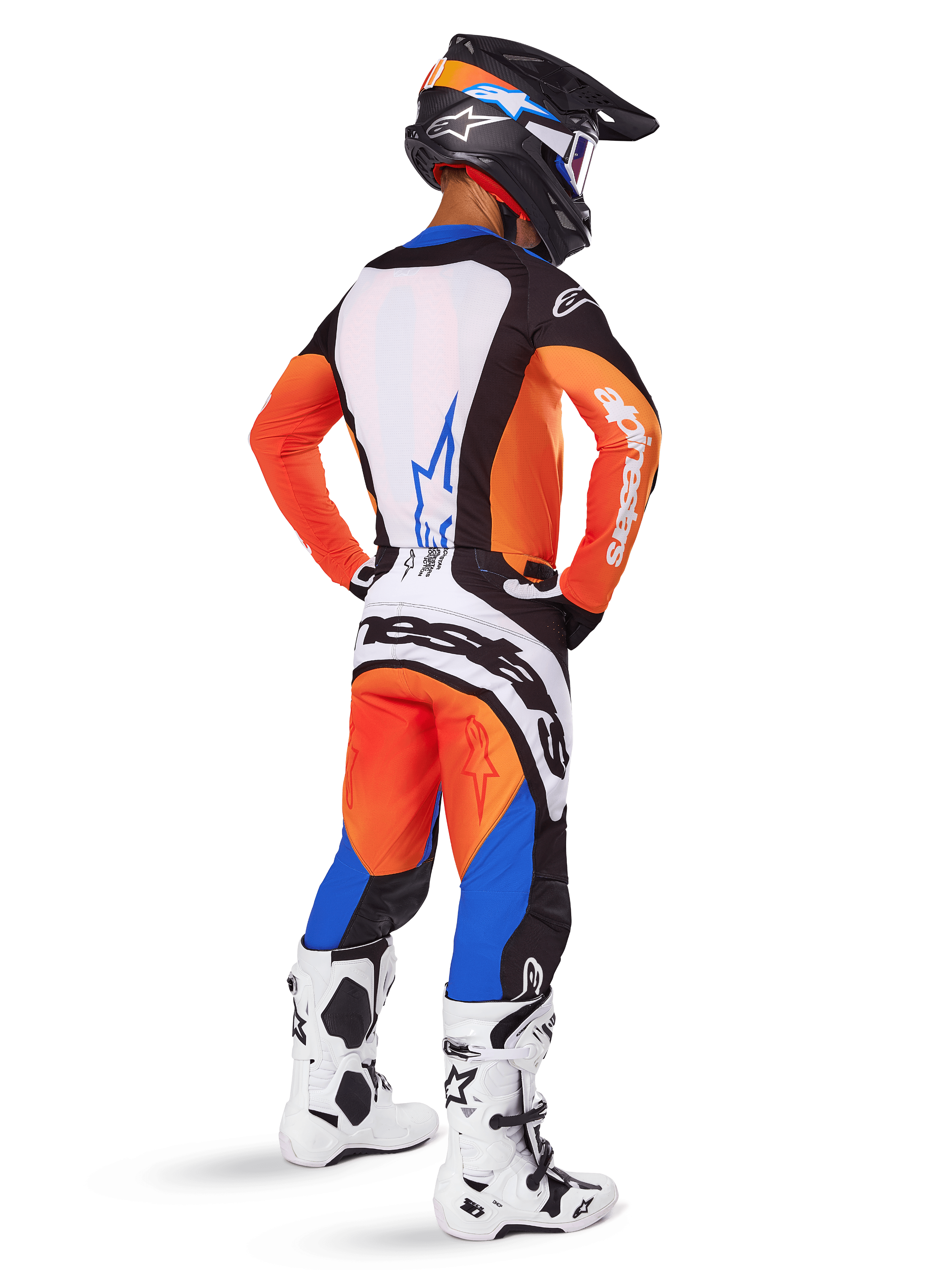 Piloto de motocross visto de costas a usar o conjunto de equipamento Techstar Melt 2025, camisola laranja e azul com painel traseiro branco e logótipo de estrela azul, calças laranja e azul a condizer com marca Alpinestars branca, capacete preto com grafismos azuis e botas de motocross brancas, conjunto de corrida todo-o-terreno coordenado.