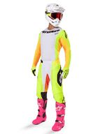 Piloto de motocross com equipamento completo Alpinestars, incluindo a camisola 2025 Techstar Melt com frente branca, painéis amarelos e mangas cor de laranja, calças amarelas e brancas, capacete branco com óculos vermelhos e botas cor-de-rosa vibrantes, kit de corrida profissional para todo-o-terreno