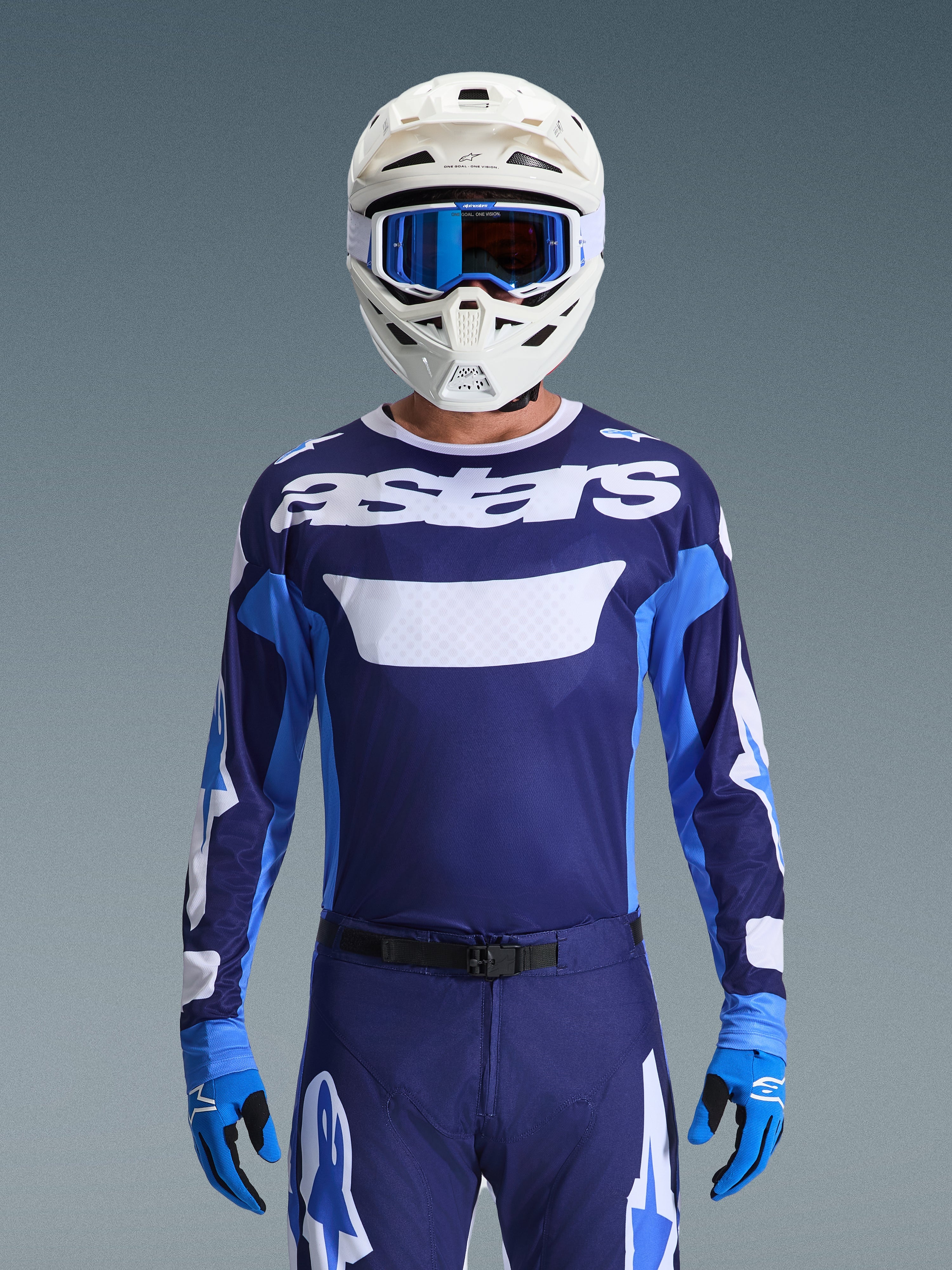 Conjunto de Equipamento Alpinestars Racer Riway 2026, camisola e calças de motocross, azul marinho e azul royal com detalhes em branco, com a marca 'astars', usado com capacete branco, óculos azuis e luvas azuis, corte atlético para desempenho em todo-o-terreno