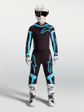 Alpinestars Camisola Supertech Vesta e Gear Set, conjunto de motocross para homem, preto e turquesa com botas e capacete brancos.