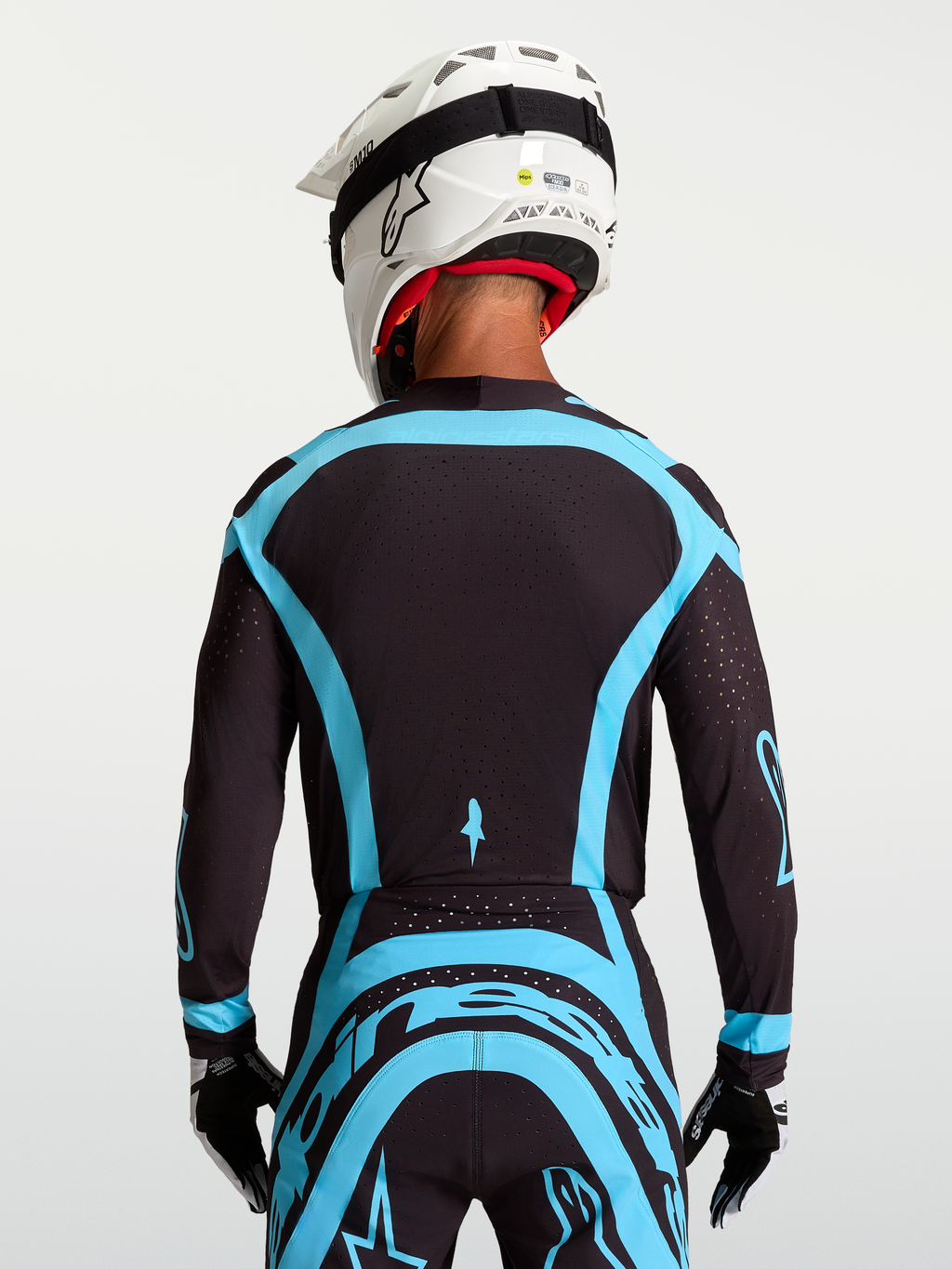 Alpinestars Supertech Vesta, camisola de motocross de nível profissional para homem, preta e turquesa, vista traseira em malha elástica com perfurações a laser.