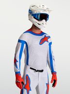 Alpinestars Camisola Supertech Vesta, camisola de motocross para corrida, branca com detalhes em vermelho e azul, malha elástica de nível profissional, ajuste atlético, vista frontal em modelo