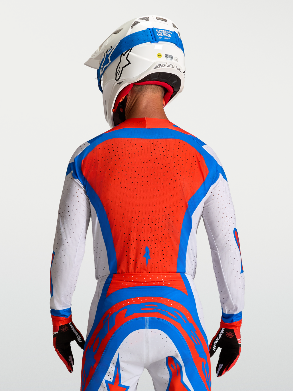 Alpinestars Camisola Supertech Vesta, camisola de motocross para homem, vermelha e branca com detalhes azuis, vista traseira com malha ventilada para alta performance.