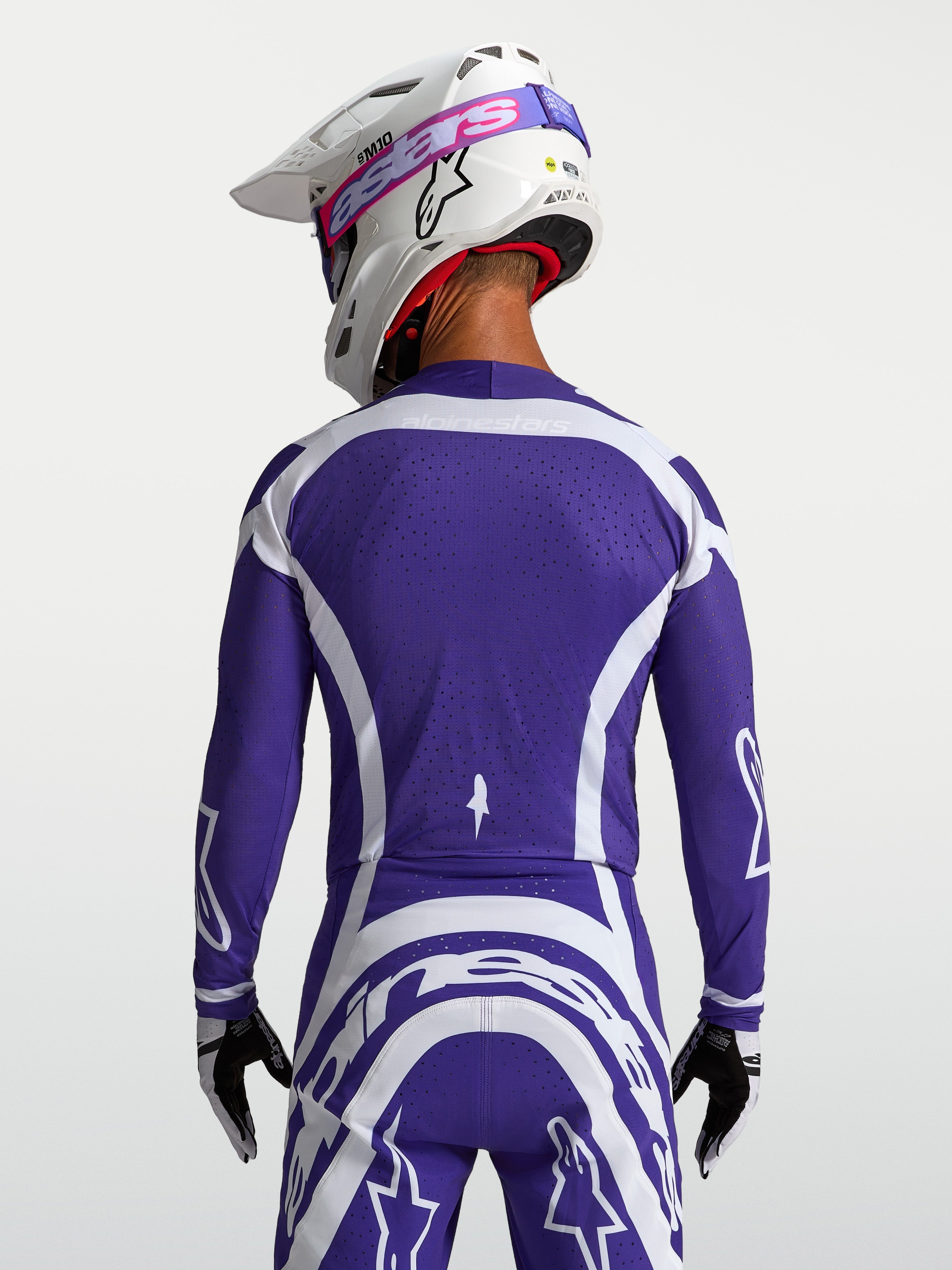 Alpinestars camisola Supertech Vesta, camisola de motocross azul escuro e branca, vista traseira com malha ventilada.