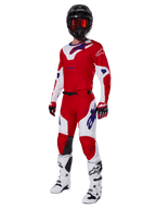 Conjunto de equipamento Alpinestars 2025 Racer Veil Gear Set, fato de competição para motocross, vermelho brilhante e branco com detalhes de logótipo azuis, usado com capacete preto, luvas vermelhas e botas brancas, conjunto protetor completo para performance todo-o-terreno
