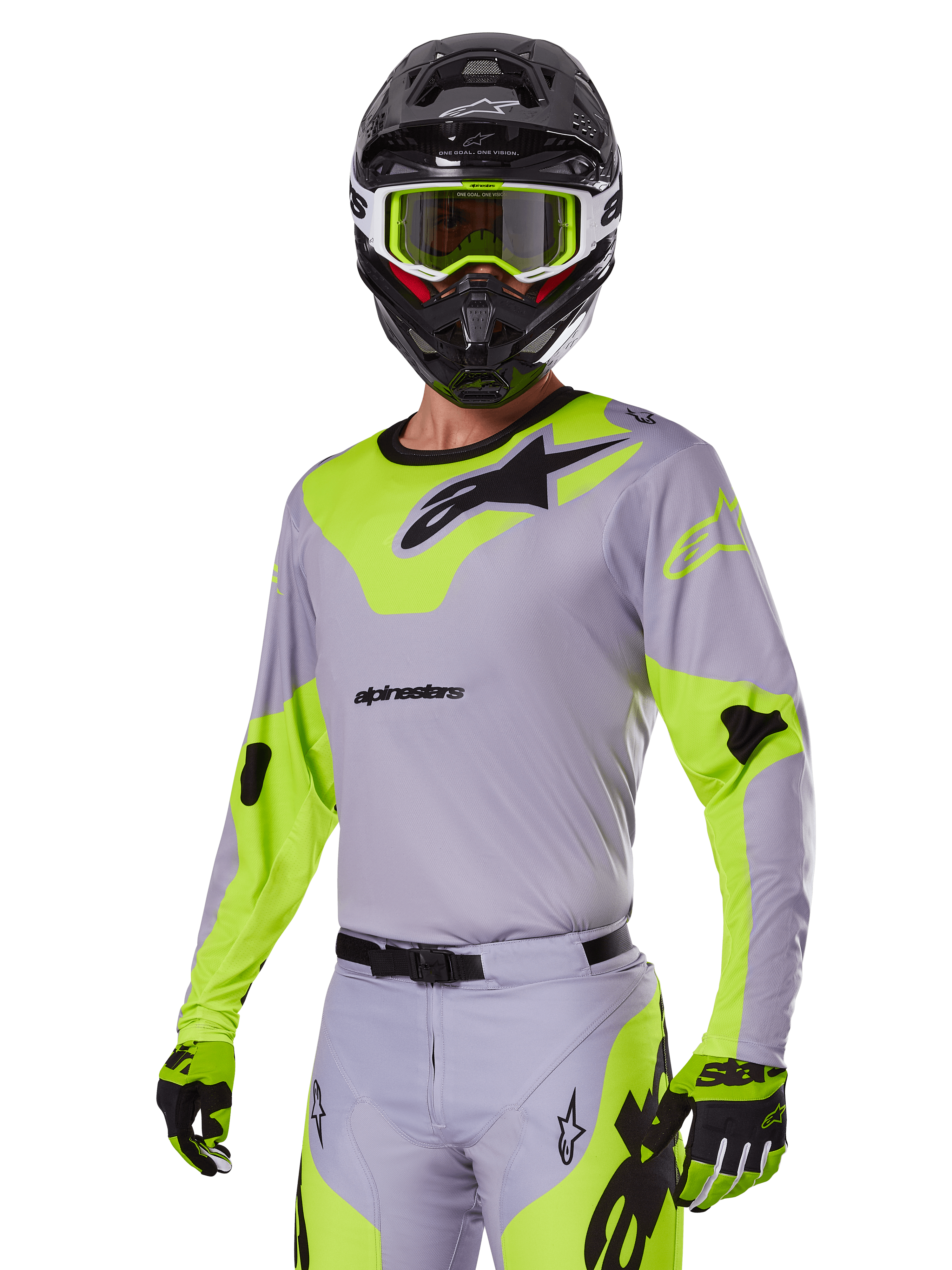 Piloto de motocross a usar o conjunto de equipamento Alpinestars Racer Veil 2025 em cinzento e verde néon, camisola e calças cinzento claro com painéis vibrantes em amarelo-verde néon e logótipos Alpinestars pretos, coordenado com luvas a condizer e capacete preto com óculos verde néon, vestuário profissional de corrida todo-o-terreno