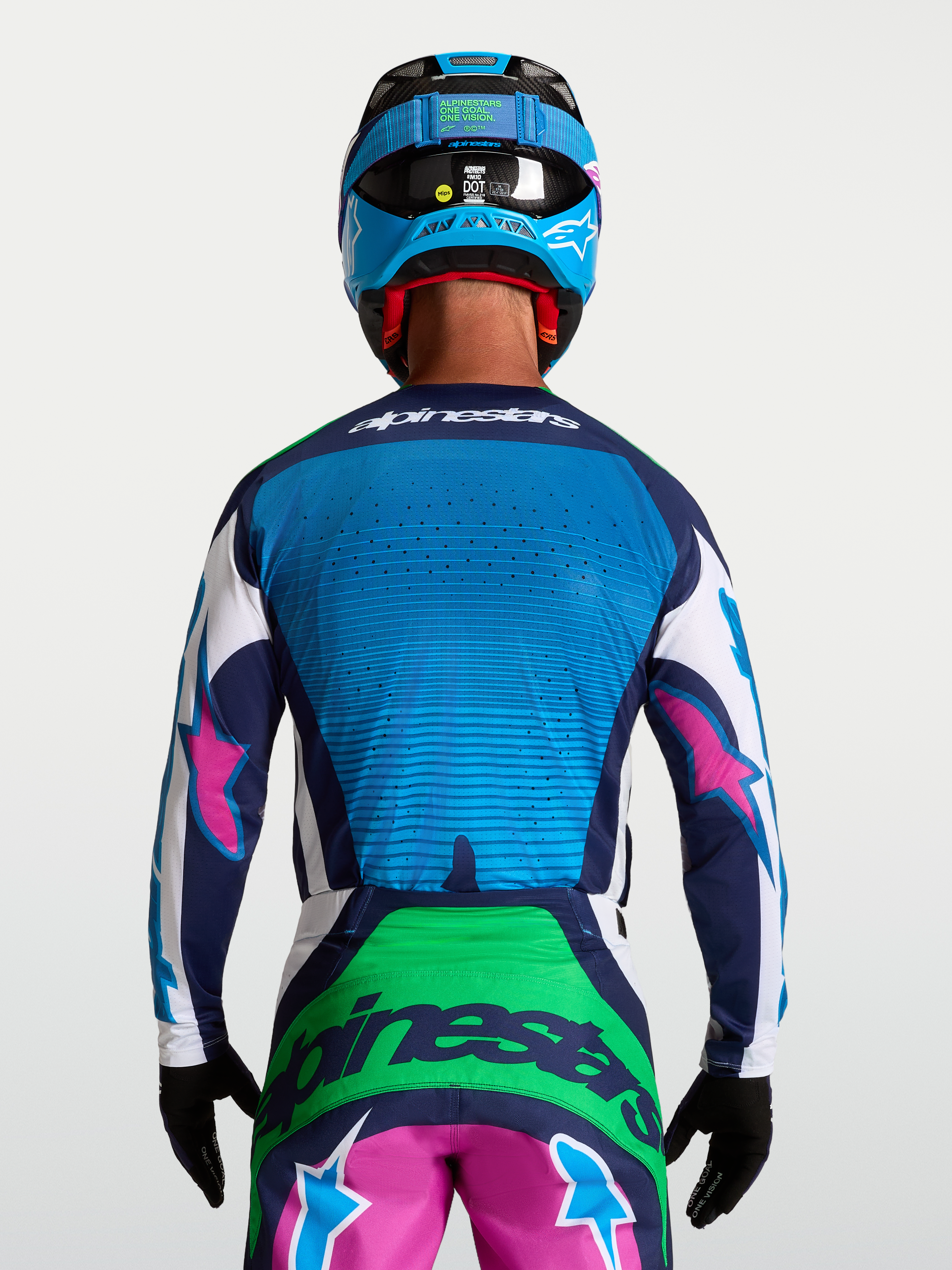 Camisola Alpinestars Techstar Maven, camisola de motocross para homem, azul e verde com detalhes rosa, vista traseira, ventilação perfurada a laser.
