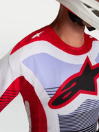Alpinestars Camisola Techstar Maven, camisola de motocross em vermelho e lavanda, pormenor das perfurações a laser no ombro e logótipo Astars no peito