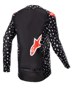 Alpinestars 2023 Supertech North Jersey, camisola de motocross, preta com padrão salpicado branco e detalhes em vermelho néon, vista traseira com grande logótipo Alpinestars vermelho e marca na parte inferior, equipamento de corrida todo-o-terreno de nível profissional