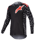 Alpinestars 2023 Supertech North Jersey, camisola de motocross, preta e vermelho néon, mangas compridas com padrão de salpicos brancos, logótipos de estrela vermelhos e brancos no peito e ombros, malha de performance leve com ajuste atlético race