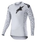 Alpinestars 2023 Supertech North Jersey, camisola de motocross, Haze Gray e preto, camisola branca de manga comprida com padrão de manchas cinzentas nas mangas e laterais, logótipo de estrela preto no peito e ombros, malha elástica de performance com bainha curva