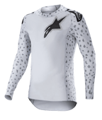 Alpinestars 2023 Supertech North Jersey, camisola de motocross, Haze Gray e preto, camisola branca de manga comprida com padrão de manchas cinzentas nas mangas e laterais, logótipo de estrela preto no peito e ombros, malha elástica de performance com bainha curva