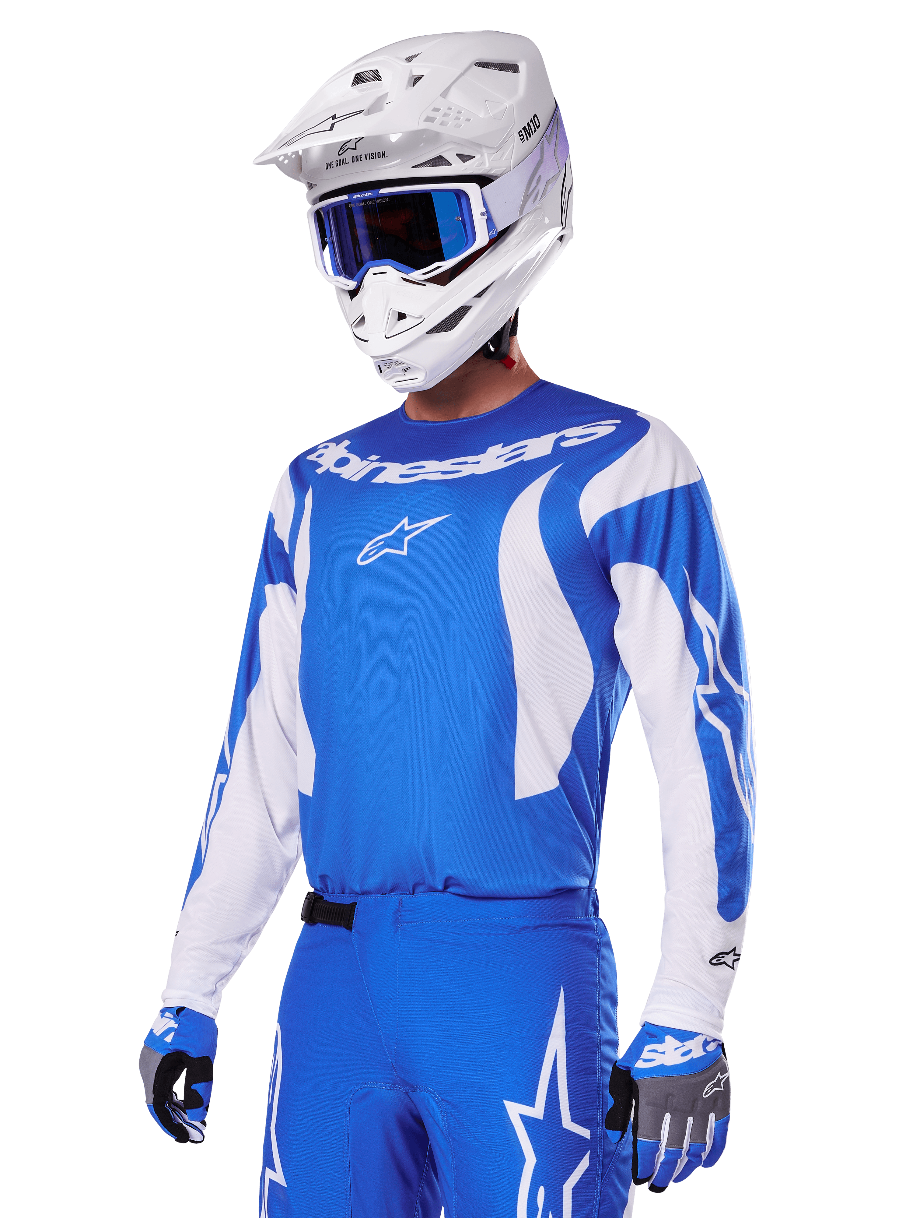 Piloto de motocross com o conjunto de equipamento Alpinestars 2025 Fluid Haul em azul e branco, camisola azul com detalhes brancos, calças azuis com logótipos de estrela, capacete branco com óculos azuis e luvas em azul e cinzento, equipamento completo de corrida todo-o-terreno