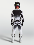 Alpinestars Techstar Swan, camisola e conjunto de motocross para homem, preto e branco, vista traseira com gráficos de salpicos, equipamento técnico para todo-o-terreno.