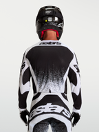 Alpinestars Techstar Swan, camisola de motocross para homem, preta e branca, vista traseira com ajuste atlético e gráficos.