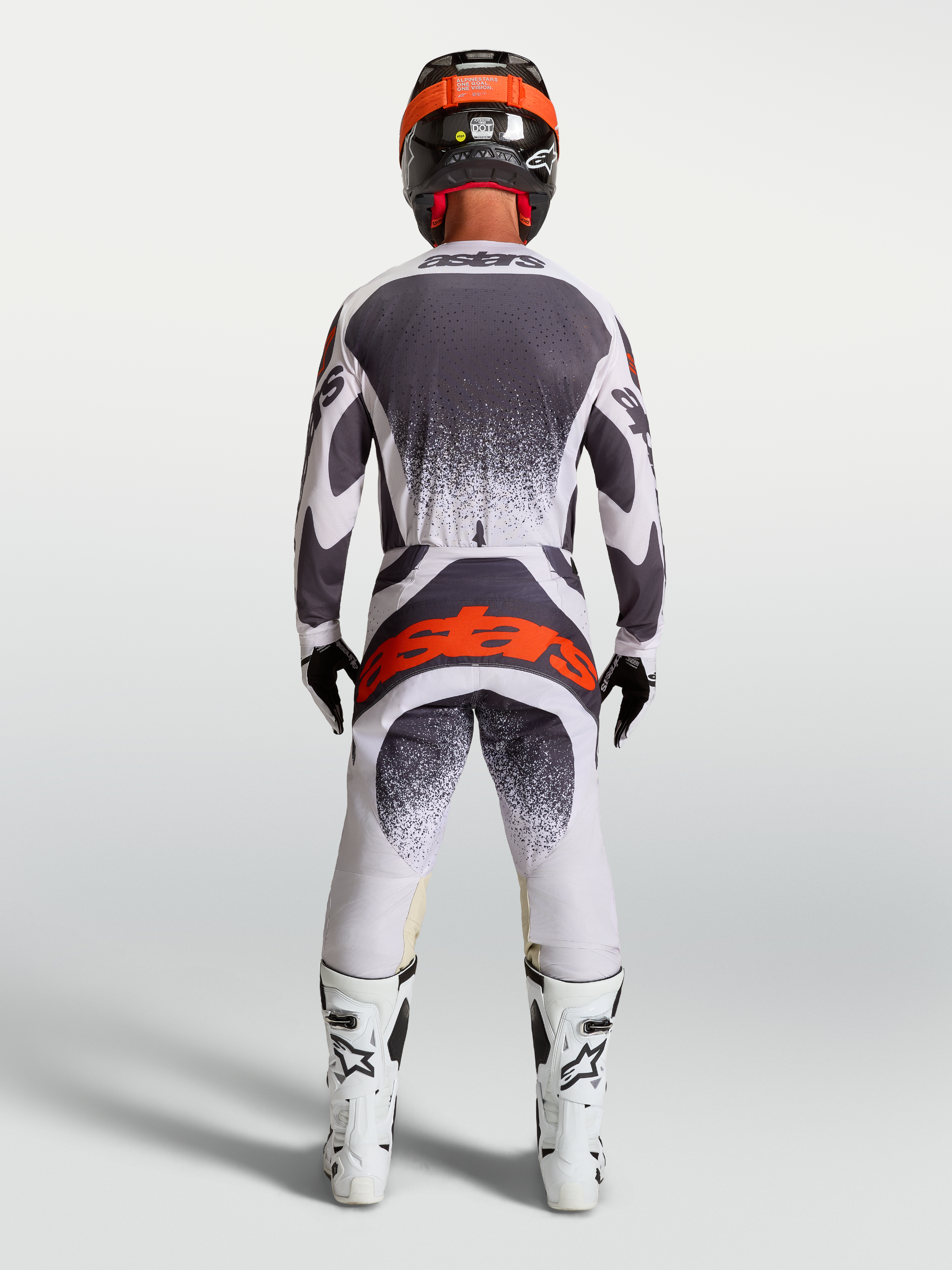 Alpinestars Camisola Techstar Swan e Gear Set, equipamento de motocross cinzento e branco com logótipo vermelho, vista traseira.