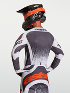 Alpinestars Camisola Techstar Swan, camisola de motocross em cinzento e branco com detalhes vermelhos, vista traseira no piloto, ajuste atlético