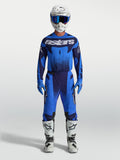 Alpinestars Techstar Swan Gear Set e Camisola Techstar Swan, conjunto de motocross para homem, azul e azul escuro, ajuste atlético de corrida, modelo a usar equipamento completo de todo-o-terreno com botas brancas e capacete.