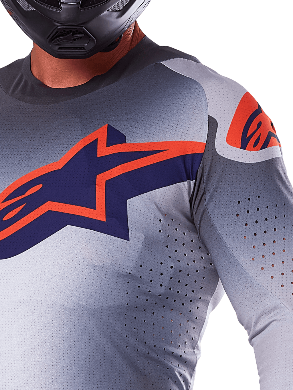 Camisola Alpinestars 2025 Supertech Lipan, camisola de motocross, cinzenta e laranja fluo, com grande logótipo de estrela em azul marinho e laranja no peito, perfurações a laser para ventilação, construção em malha leve, usada com um capacete preto