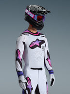 Piloto de motocross a usar a Camisola 2026 Supertech AFD Vista em Branco Roxo e Preto, calças brancas e roxas a condizer, capacete preto com óculos roxos e luvas brancas, equipamento profissional completo de corridas todo-o-terreno.