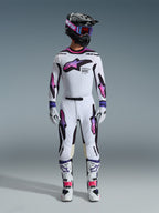 Piloto de motocross com equipamento de corrida completo, camisola Alpinestars 2026 Supertech AFD Vista em branco, roxo e preto, calças brancas a condizer com grafismos em degradê roxo e rosa, botas brancas e capacete preto com óculos roxos, conjunto profissional para todo-o-terreno