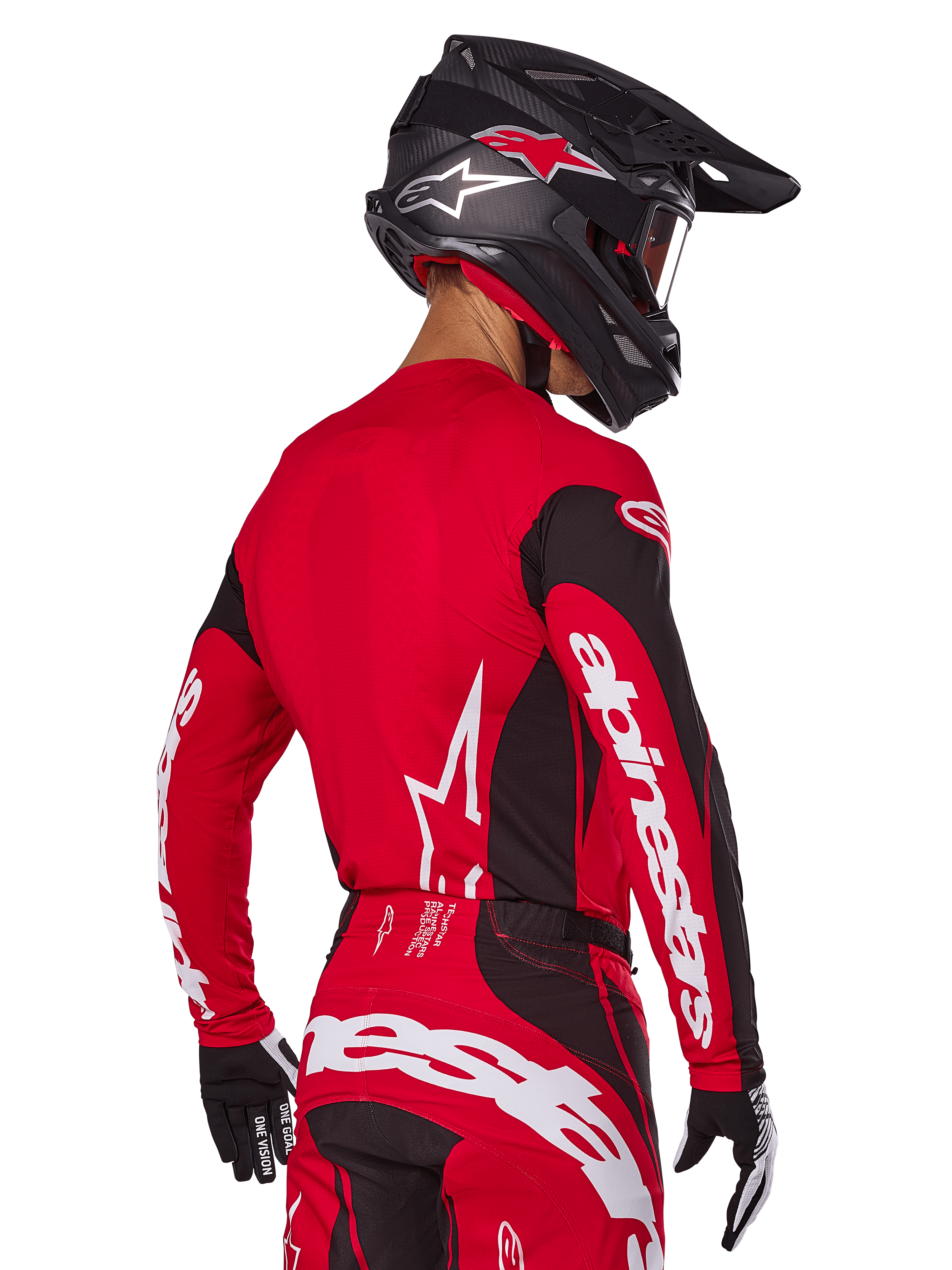 Piloto de motocross visto de costas a usar o conjunto de equipamento Alpinestars 2025 Techstar Dreem, camisola vermelha e preta com logótipo branco nas mangas, calças vermelhas e pretas condizentes com logótipo branco no assento, capacete de carbono preto com detalhes vermelhos, luvas pretas e brancas, equipamento de corrida profissional para todo-o-terreno